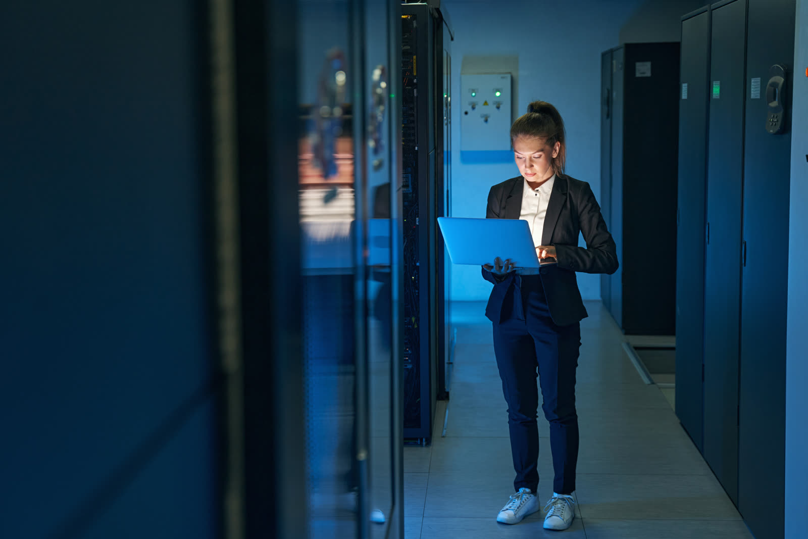 A technician working at a server rack — the staffed, accountable infrastructure operators behind Djeed's Swiss-sovereign hosting